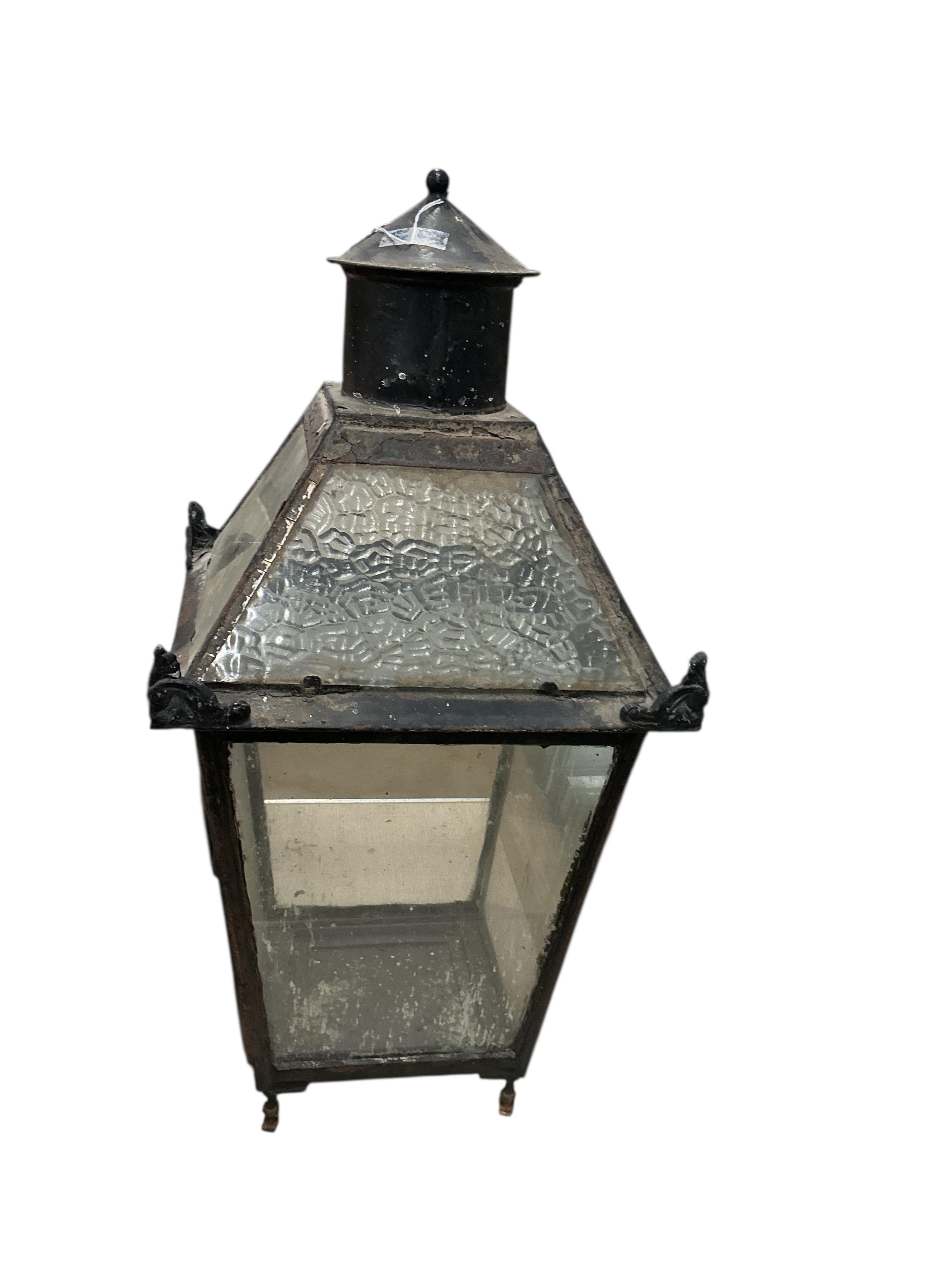 A glass and steel railway station lantern with an opaque glass panel showing the remains of a painted possible station name, missing the burner etc., 80cm high, 40cm wide